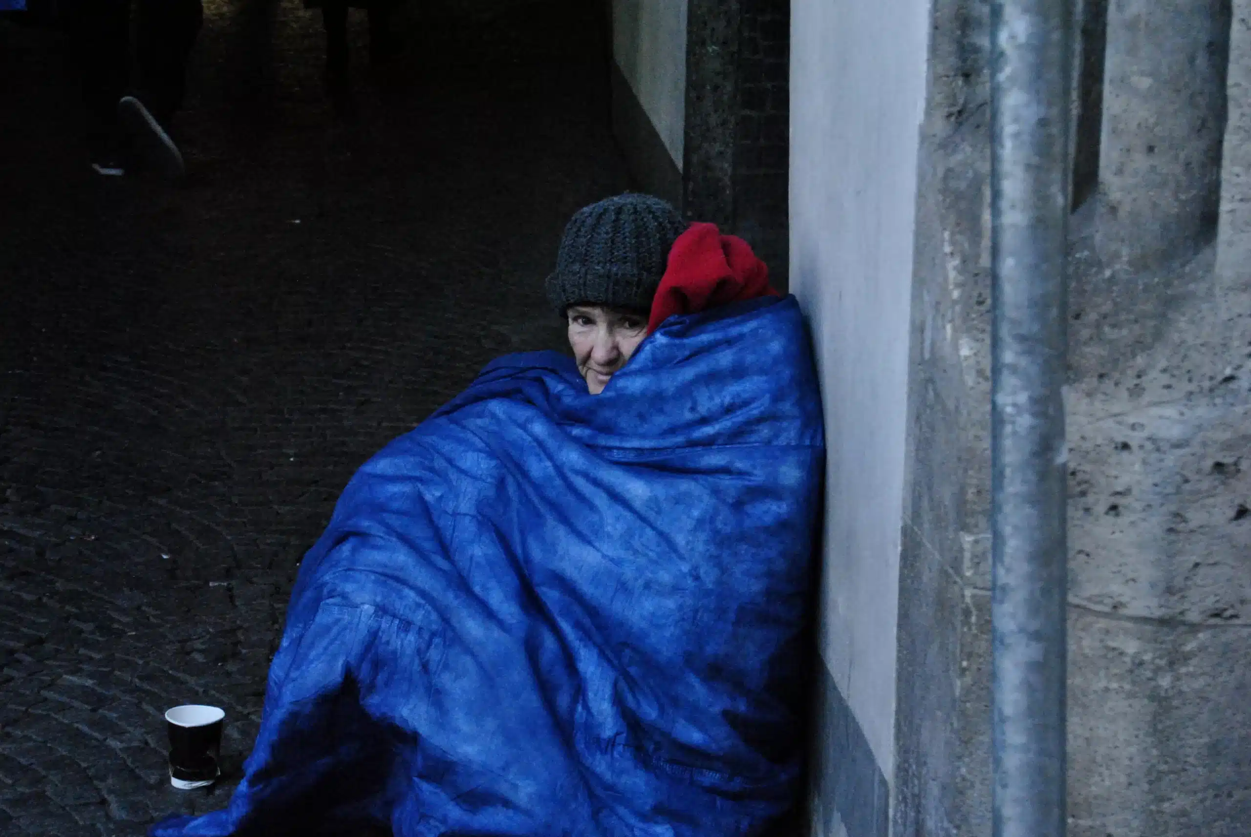 Donna senzatetto seduta a terra in strada