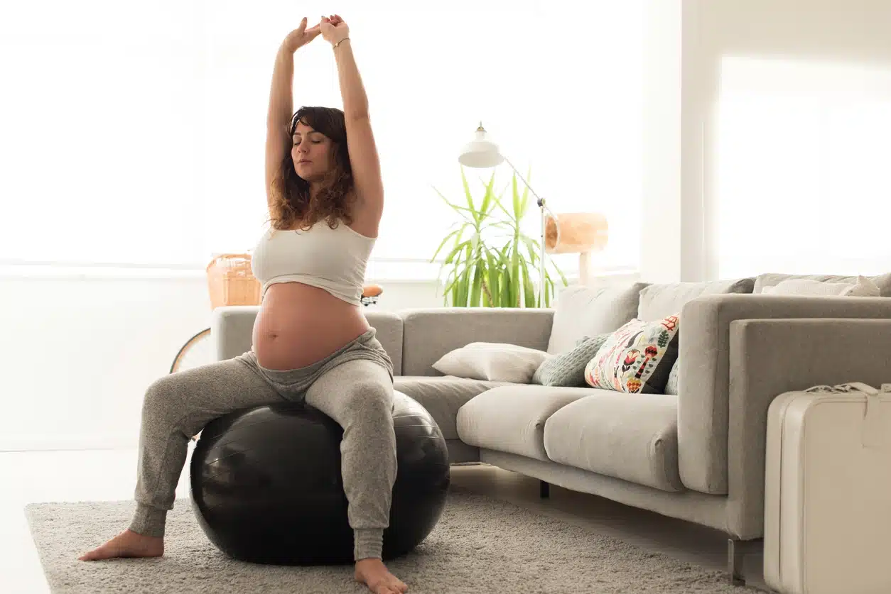 Donna incinta seduta su una palla per esercizi
